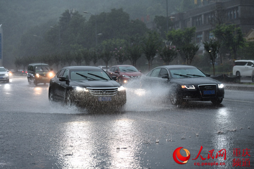 7月22日下午，重庆渝北突降暴雨，古木峰立交附近出现少量积水，车辆经过激起层层“浪花”。邹乐 摄