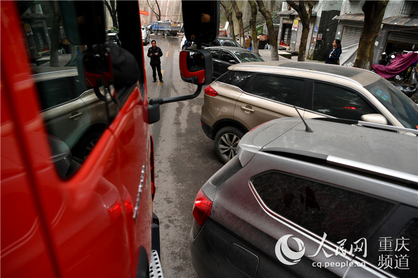 瑪瑙小區道路兩旁車輛佔道現象嚴重，消防車通過困難距離兩旁車輛不足半米。郭旭 攝