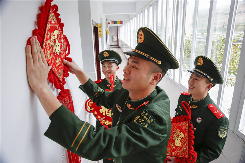 官兵们正在营区楼道悬挂中国结。彭勇摄