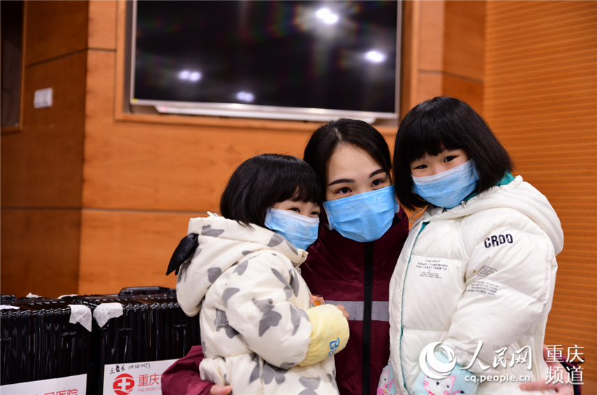 2月11日，重慶市璧山區人民醫院重症醫學科護士王春蘭的5歲女兒和3歲女兒趕到醫院為媽媽加油。胡悅建 攝