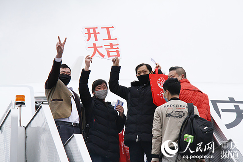 登機后的務工人員向工作人員揮手致謝。重慶機場供圖