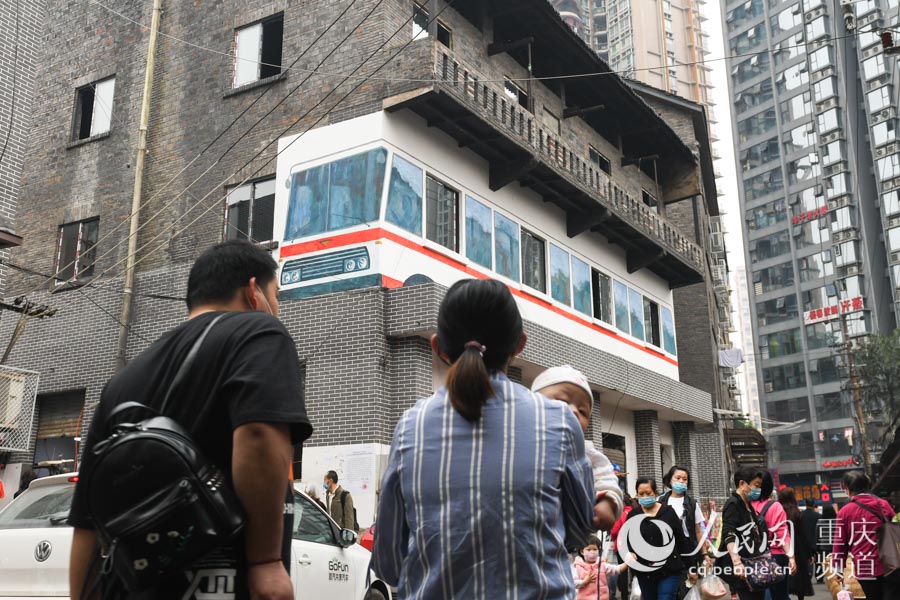 遠遠望去，仿佛一輛行駛的公交車“穿樓”而過，十分逼真。鄒樂 攝