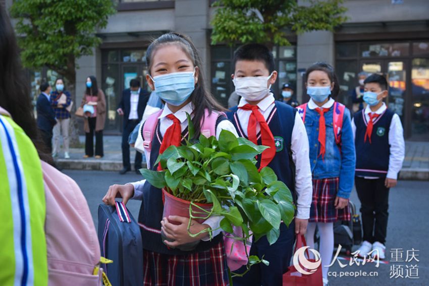 4月27日，重慶高新區樹人思賢小學，學生抱著綠蘿准備進入校園。鄒樂攝