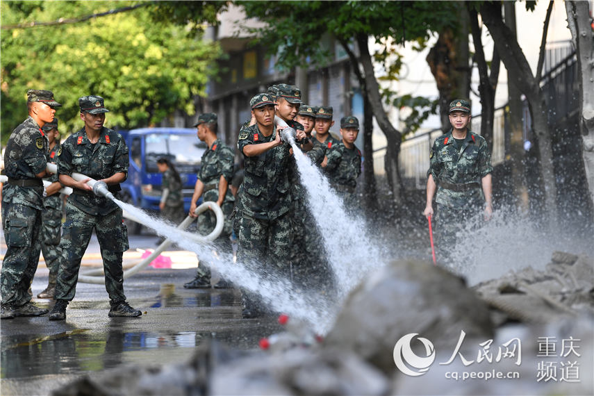 8月20日，在重慶市北碚區朝陽街道，武警重慶總隊機動支隊官兵正在對積水和淤泥進行清理。王肸 攝