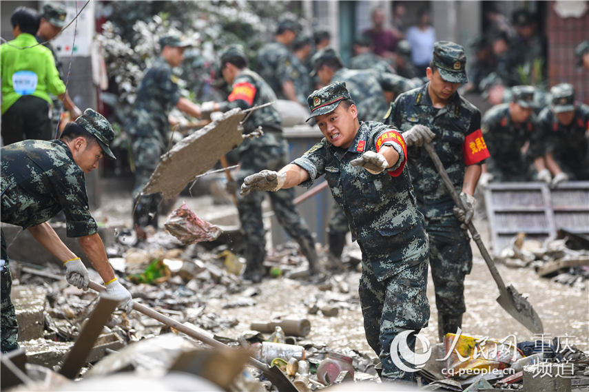8月21日，在重慶市北碚區童家溪鎮同興老街，武警重慶總隊機動支隊官兵正在對街道淤泥、積水和垃圾進行清理。王肸 攝