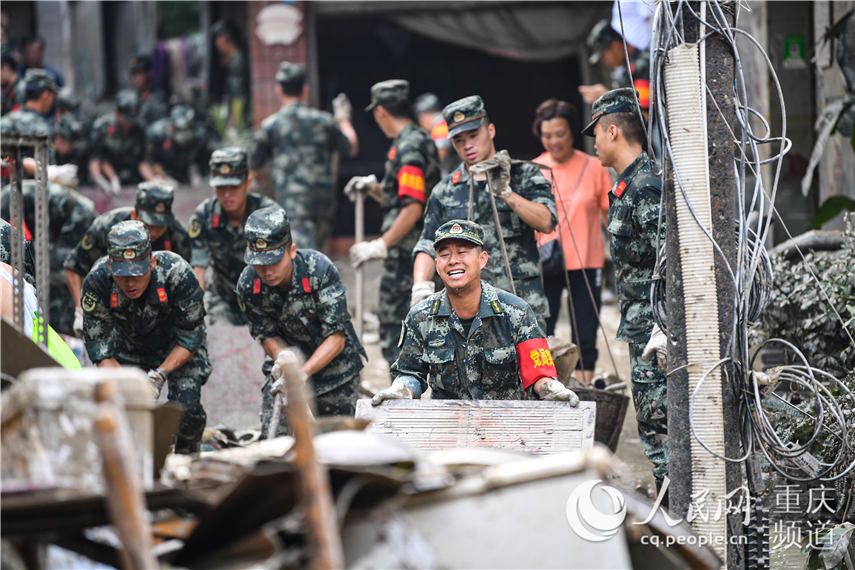 8月21日，在重慶市北碚區童家溪鎮同興老街，武警重慶總隊機動支隊官兵正在對街道淤泥、積水和垃圾進行清理。王肸 攝