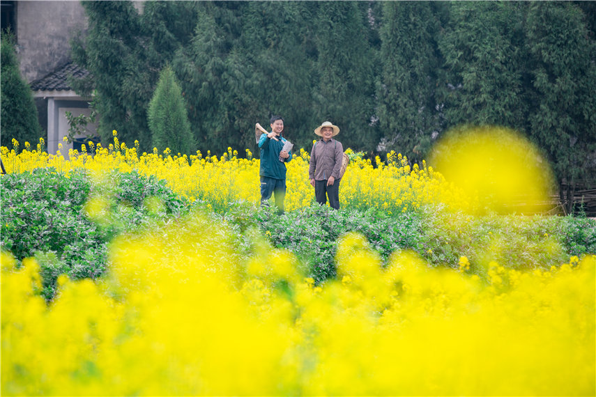 鄉村郵遞員廖飛與村民同行。朱亞坤攝