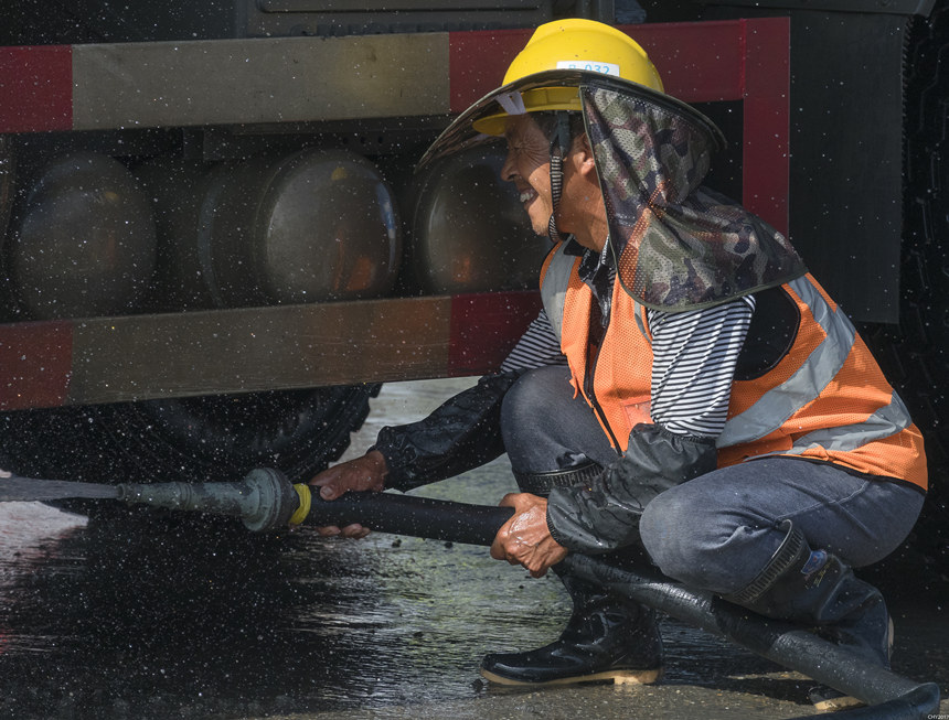 8月2日下午，中建三局三公司重庆vivo项目工人为货车冲洗排污。陈恒勇摄