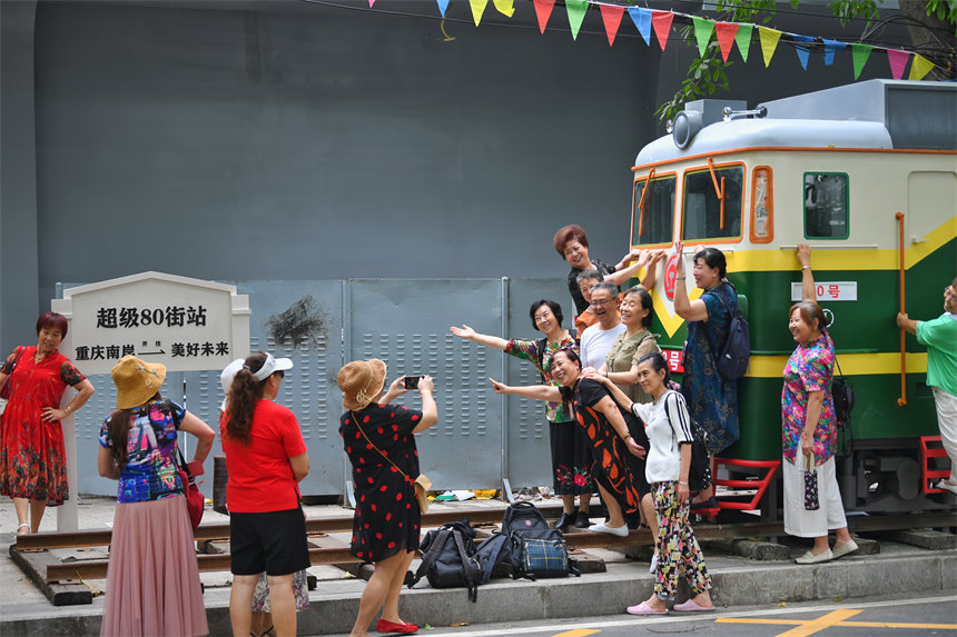 市民以“绿皮火车”为背景拍照打卡，给老街增添了人气与活力。郭旭摄