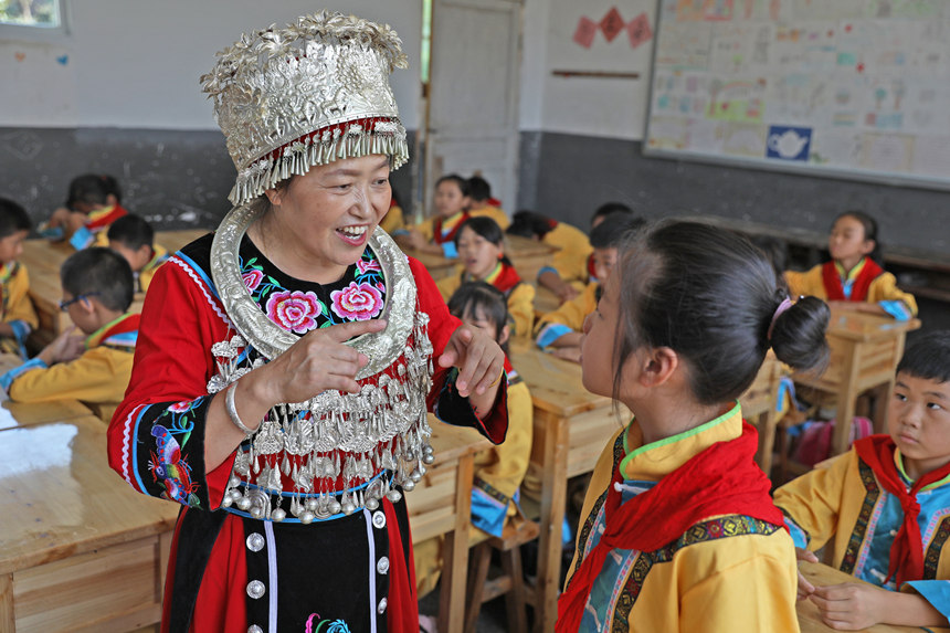 “苗族民歌”非物質文化遺產傳承人任茂淑正在指導學生傳唱苗族民歌。趙勇攝