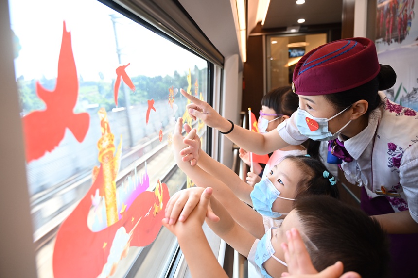 10月2日，“復興號”智能動車組列車上乘務員與孩子們一起玩耍。包亮攝