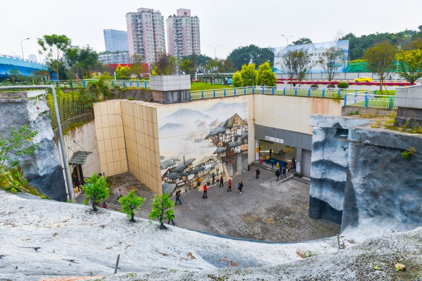重慶軌道交通彈子石站4號出口，高達10米的水泥擋牆繪制成兩幅巨型壁畫，既美化了軌道站周邊環境，還形成了一個新的網紅打卡點。鄒樂攝