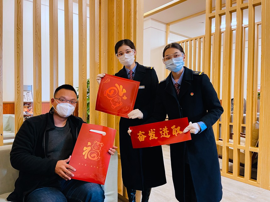 旅客收到重庆西站“红岩服务站”工作人员赠送的“福”袋后，面向镜头开心的展示。徐晨茜摄