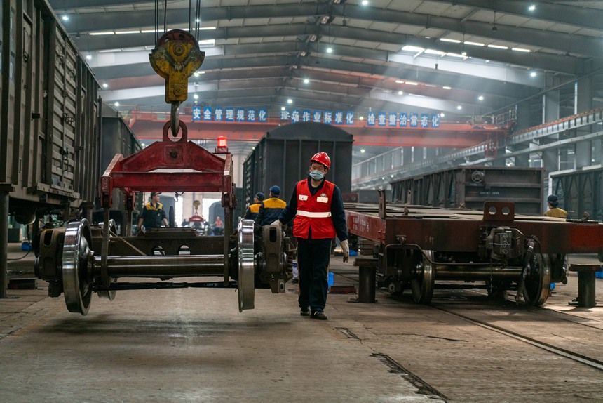 中國鐵路成都局集團有限公司重慶西車輛段檢修車間鉤緩組車輛鉗工正在進行行車低空吊運指揮。劉彪攝