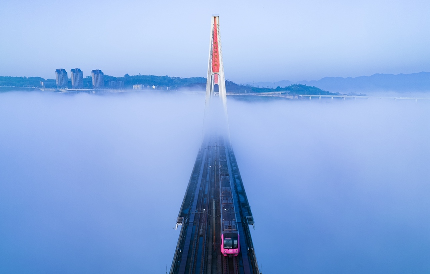 晨霧中，一列軌道列車從蔡家軌道專用橋上駛過。林同棪國際（中國）公司供圖