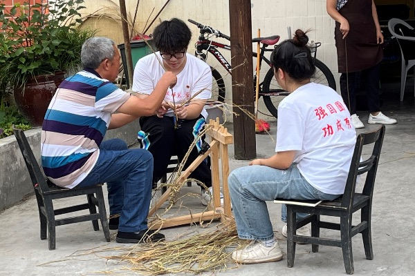 团队成员学习编织草鞋。重庆师范大学供图