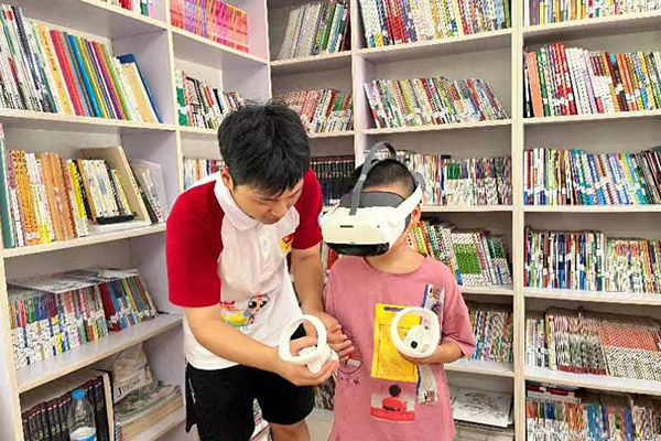 实践团成员带领当地小朋友进行VR互动体验。重庆工程职业技术学院供图