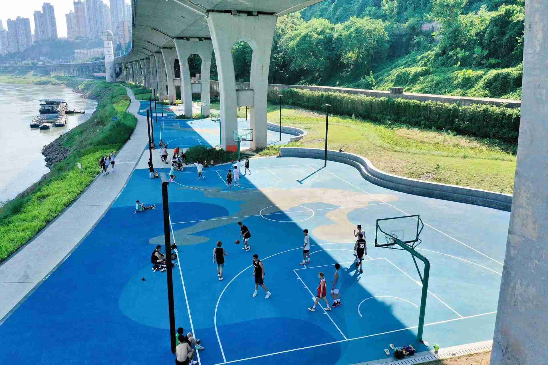 在渝中区黄沙溪大桥下，市民在长江边的篮球场打球。何超摄