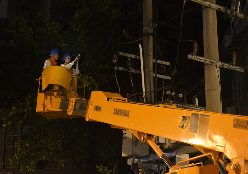 8月10日晚，国网重庆市电力公司员工在10千伏景观线4号台区测温。罗凌摄