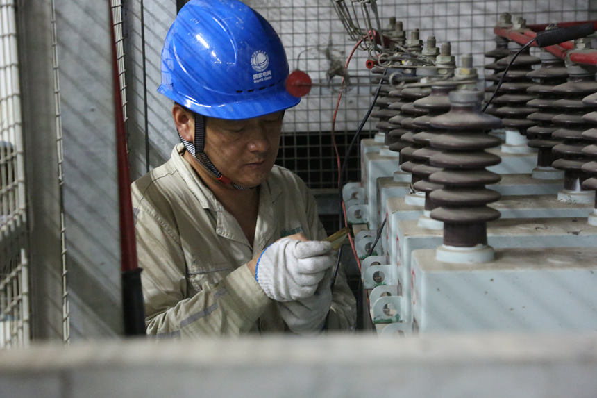8月10日晚，国网重庆市电力公司员工在110千伏大路变电站检修4号电容器。蒋佩摄