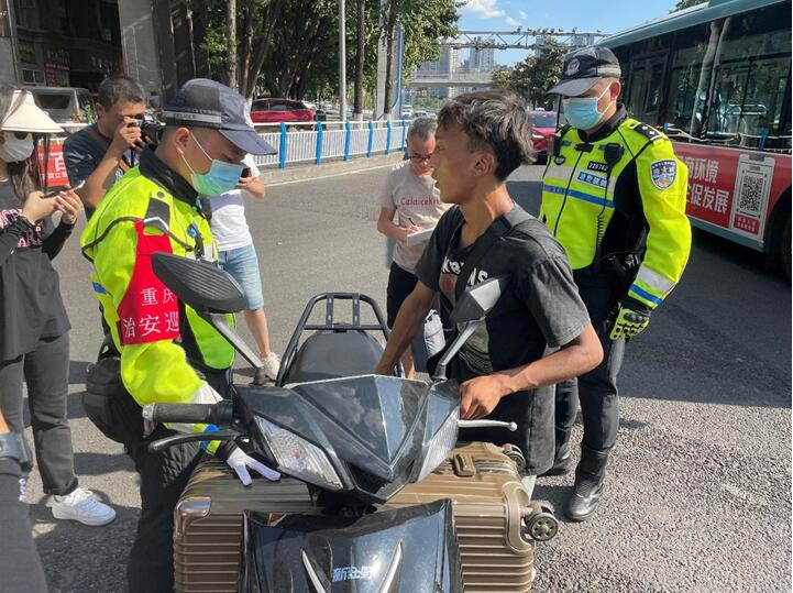 民警在街頭勸導摩托車駕駛員。實習生越倚航攝