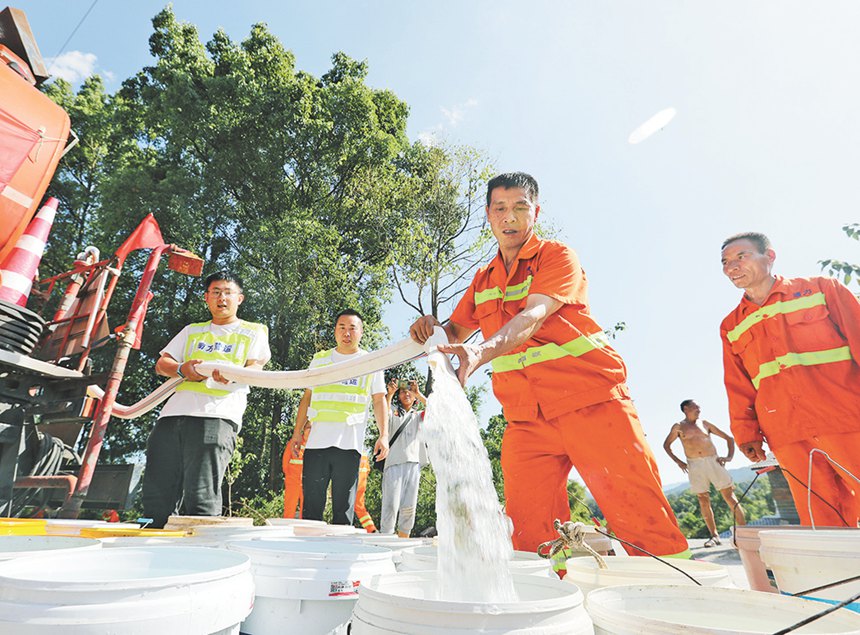 8月18日，重庆高速集团员工将饮用水送到巴南区接龙镇居民家门口。记者 罗斌 摄/视觉重庆