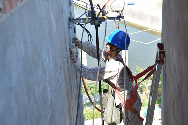 8月18日，国网重庆电力员工正在对客户下户线墙上的角铁和瓷瓶进行安装。潘洪摄