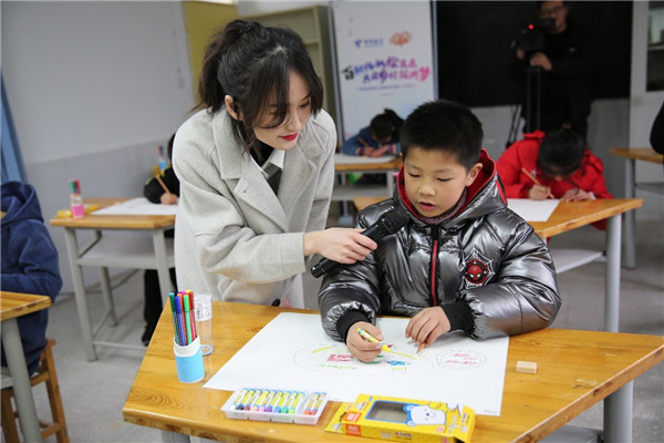 郑馨玙在爱心小屋主题活动中陪孩子们画画。受访者供图