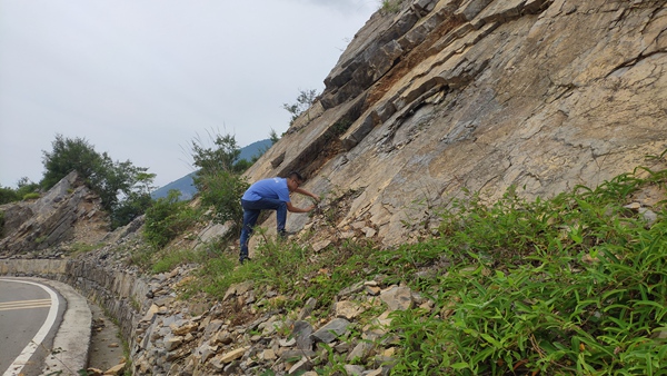 《危岩调查》。6月29日，川东南地质大队地灾驻守队员易洪志在巫山县竹贤乡福坪村调查公路沿线的危岩，对乡镇和行业部门上报的危岩点进行现场核查。龚强摄