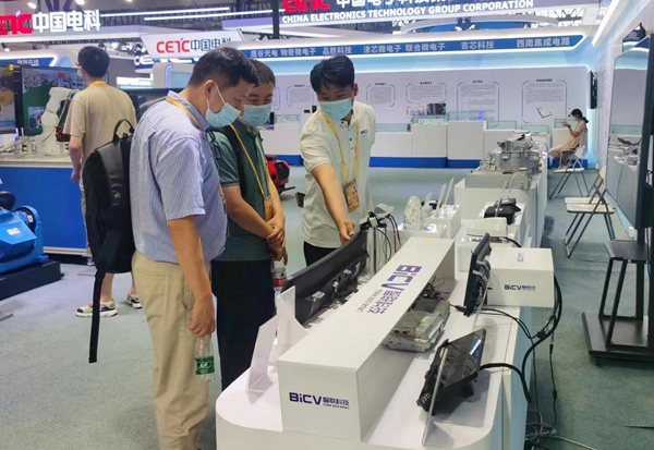 展区工作人员向参观者介绍科技产品。重庆市税务局供图