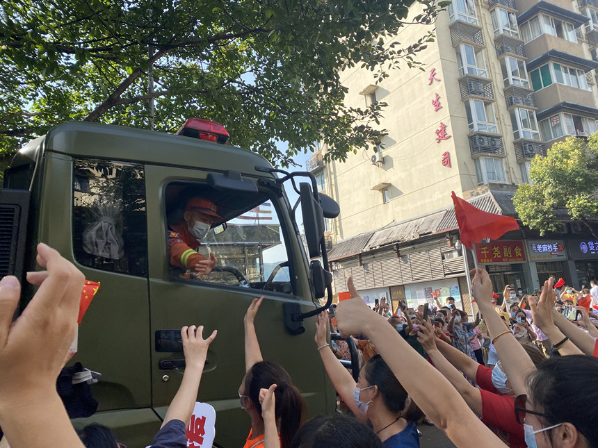 重庆市民竖着大拇指欢送灭火英雄。杨欢摄