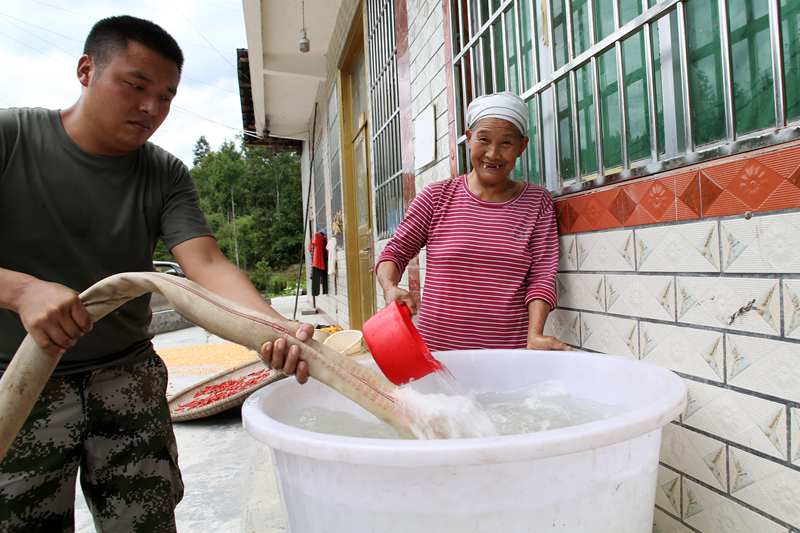 专班人员为村民送水。杨敏摄