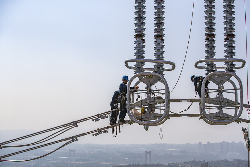 9月13日，在重庆市江津区白浙线长江大跨越施工现场，施工人员正在进行导线附件安装。黄伟摄