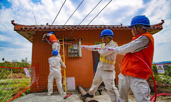 国网重庆电力员工在璧山七塘镇建设村为客户抽水房安装下户线路。蒋佩摄