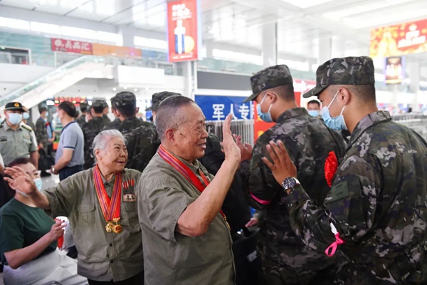 老兵肖先炳和他的爱人朱小珍，在重庆北站为入伍新兵送行。邹乐摄
