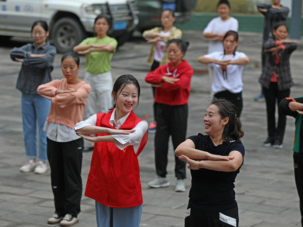 文艺志愿者引导村民一起跳苗族传统舞蹈。赵勇摄