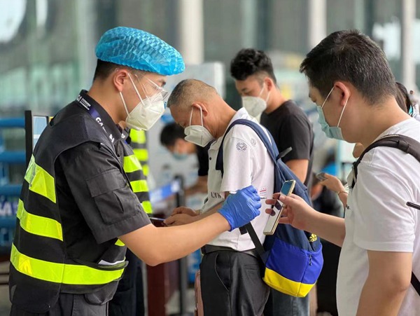 安检人员在检查健康码、行程码和核酸报告。重庆江北机场供图