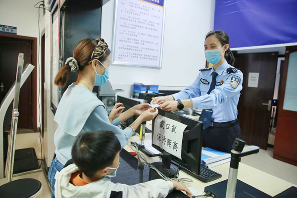 林女士领取儿子的第一张居民身份证。重庆市公安局治安管理总队供图