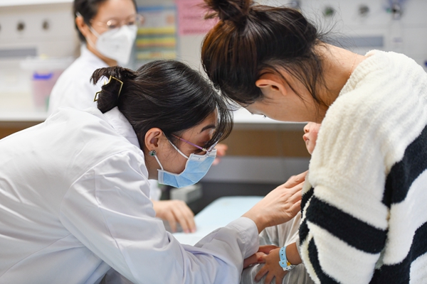 感染科主任医师张祯祯（左）查看患者情况。邹乐摄
