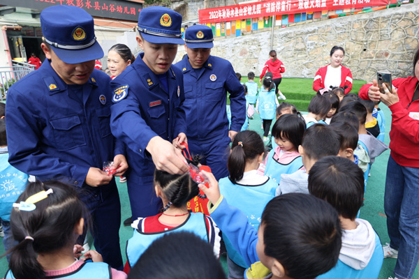 消防员给小朋友发放礼品。彭水县消防救援大队供图