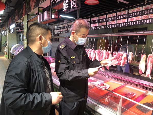 九龙坡区市场监管局执法人员检查超市肉制品质量。