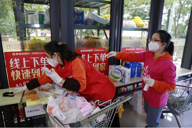 “突击队员”正在新世纪超市九龙广场店打包线上订购商品。重庆百货供图