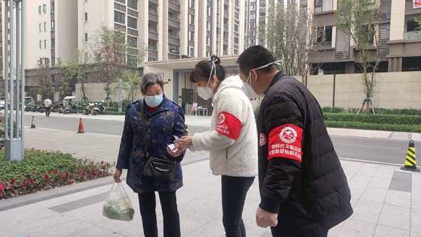 李琦在小区门口查看社区居民的健康码。重庆市妇联供图