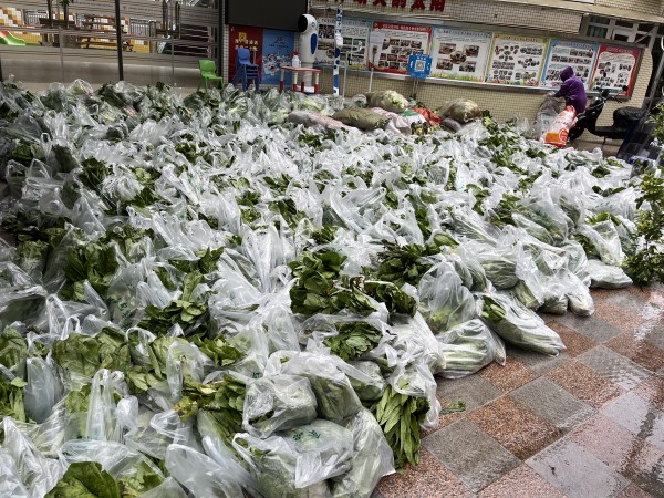 民警和志願者將蔬菜分批下貨、裝袋。沙坪壩區公安分局供圖