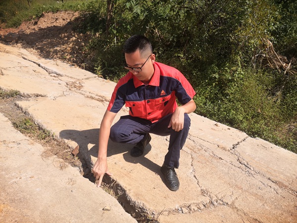 《地面裂缝调查》。10月20日，南江地质队驻守地质队员陈旭在武隆区芙蓉街道瓦厂湾滑坡调查地面裂缝。陈志荣摄。