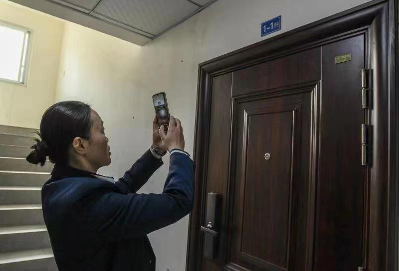 重庆市江津区锦江半岛小区居民周琳扫描自家门牌上的二维码。王化全  摄