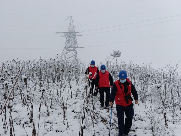 12月30日，国网重庆电力员工在开州区顶星村踏雪巡视线路。陈旭摄