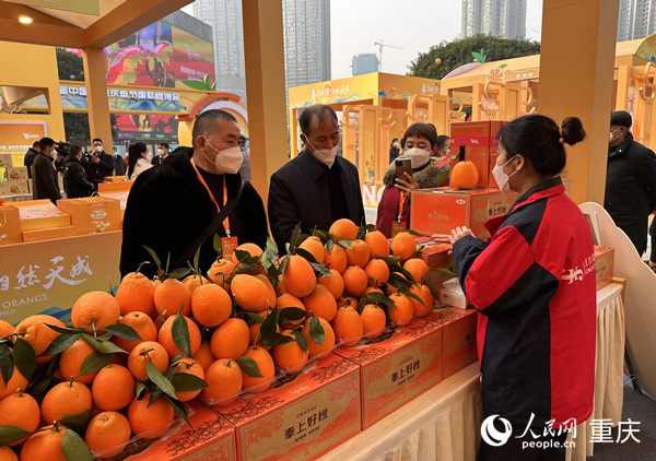 市民在观音桥商圈展示推介区选购脐橙。人民网 刘政宁摄
