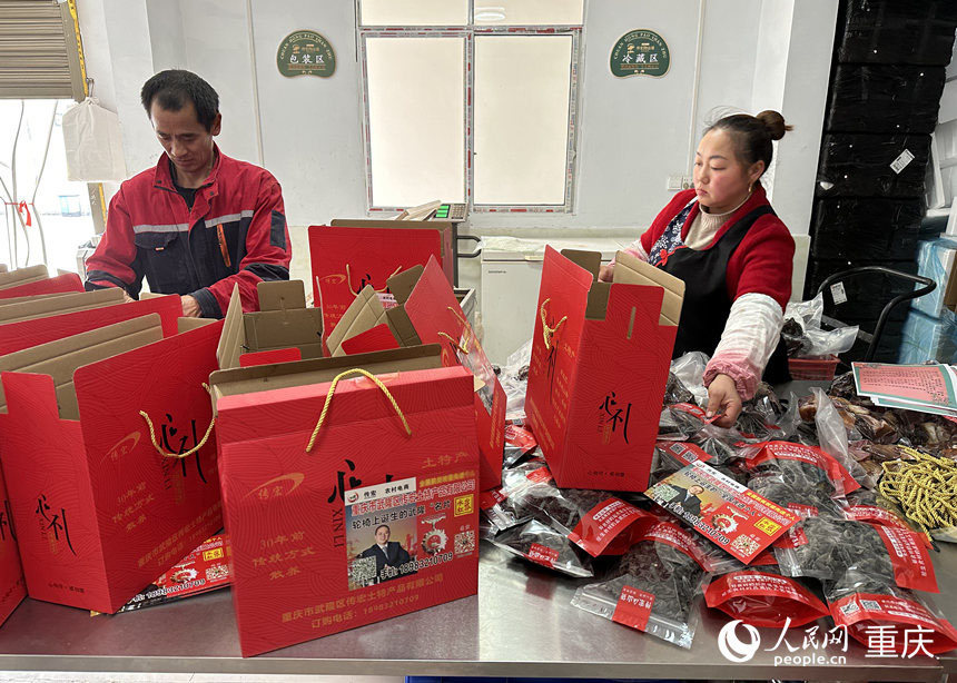 胡文超（左）在打包农副产品。人民网 刘政宁摄