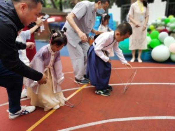 家長陪伴孩子一起體驗民俗游戲。重慶市渝北慶齡幼兒園供圖